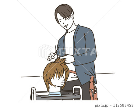 ヘアマネキンでカット練習をする男性美容師 112595455
