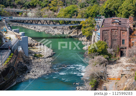 天ケ瀬ダムの上から見た宇治川と旧宇治川電気志津川発電所跡　京都府宇治市 112599283