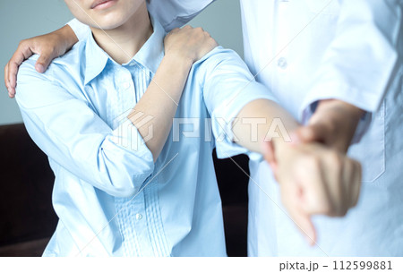 Female physiotherapists provide physical assistance to patients with shoulder injuries massaging their shoulders for muscle recovery in the rehabilitation center. Physiotherapy concepts 112599881