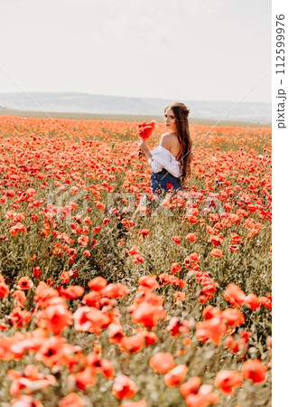 Woman poppies field. Side view of a happy woman with long hair in a poppy field and enjoying the beauty of nature in a warm summer day. 112599976