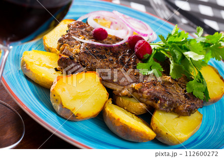 Beef steak with slices of baked potato Beef steak with slices of baked potato 112600272