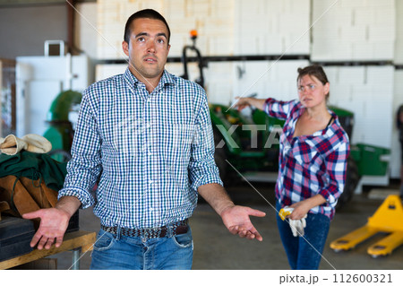 Dissatisfied female farmer talking to shrugging workman Dissatisfied female farmer talking to shrugging workman 112600321