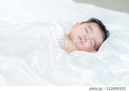 シーツに包まれて眠る生後4ヶ月の男の子 112600332
