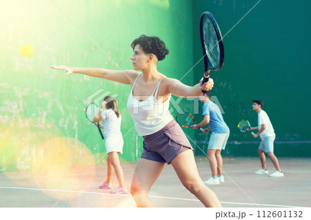 Young Argentinian woman playing frontenis at open-air fronton in summer 112601132