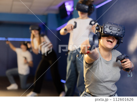 girl in virtual reality helmet crouches down and dodges flying asteroids during space adventure game 112601626