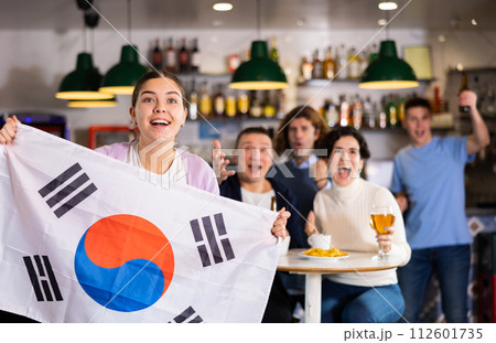 Group of happy friends with flag of South Korea celebrating victory of their favorite team in beer bar 112601735