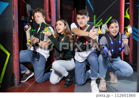 Laser tag players young mens and womens playing in teams in dark laser tag station 112601860