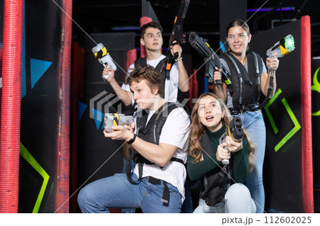 Four people with lasertag guns squatting in arena 112602025