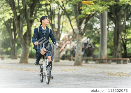 公園の中を自転車通学する制服姿の中学生・高校生の女の子 公園の中を自転車通学する制服姿の中学生・高校生の女の子 112602078