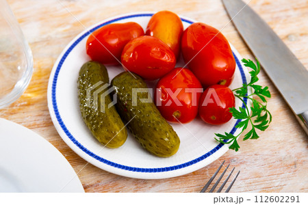 Homemade marinated tomatoes and cucumbers on plate 112602291