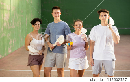 Two happy couples after playing paleta fronton on tennis court Two happy couples after playing paleta fronton on tennis court 112602527