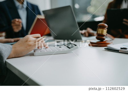 Justice and law concept. Team judge in a courtroom the gavel, working with digital tablet computer on table in sun light. Justice and law concept. Team judge in a courtroom the gavel, working with digital tablet computer on table in sun light. 112602529