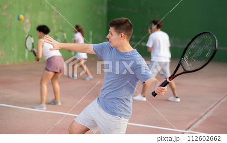 Man playing frontenis with partners at sunny day, healthy lifestyle concept Man playing frontenis with partners at sunny day, healthy lifestyle concept 112602662