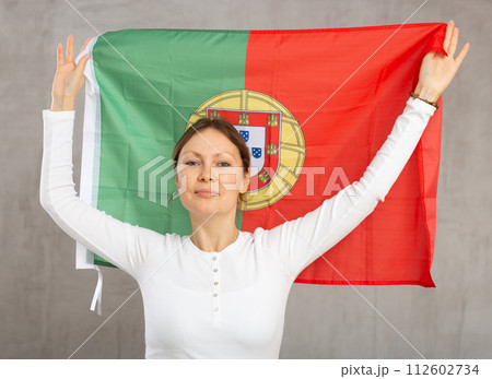 Happy woman posing with national flag of Portugal in studio 112602734