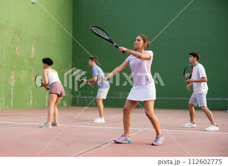 Woman playing frontenis with partners at sunny day, healthy lifestyle concept 112602775