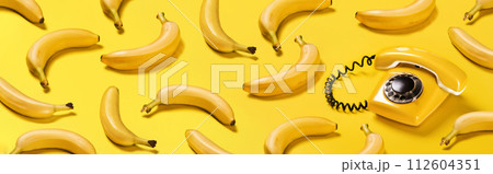 Banner bananas and old yellow phone with hard shadows pattern on yellow background flat lay bananaphone 112604351