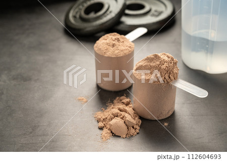 Chocolate protein powder in scoops. Food supplement, nutrition Chocolate protein powder in scoops. Food supplement, nutrition 112604693