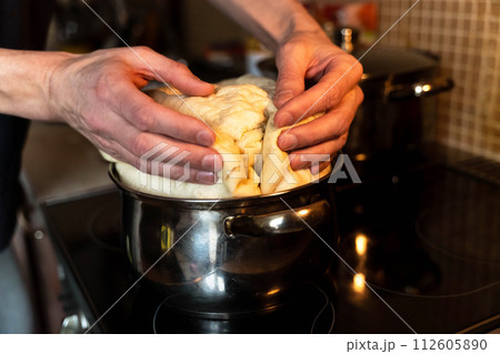 Professional chef kneading sourdough on stove for baking bread Professional chef kneading sourdough on stove for baking bread 112605890