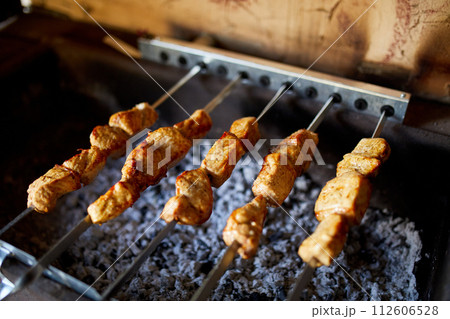 Summer Barbecue at Home Featuring Kebabs Grilling in a Backyard Grill 112606528