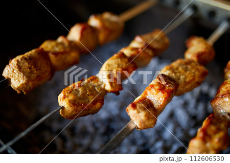 Summer Barbecue at Home Featuring Kebabs Grilling in a Backyard Grill Summer Barbecue at Home Featuring Kebabs Grilling in a Backyard Grill 112606530