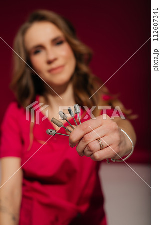 Manicure milling and cutters in women's hands. Device for removing gel varnish. Banner for insertion into site. Place for text cope space. Electric manicure machine 112607341