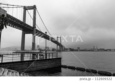 雨に濡れた海沿いのデッキと橋の風景 112609322
