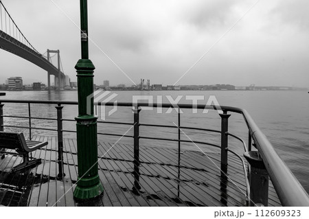 雨に濡れた海沿いのデッキと橋の風景 雨に濡れた海沿いのデッキと橋の風景 112609323