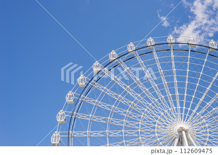 Part of ferris wheel in white color against summer blue sky 112609475