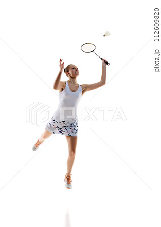 Concentrated young girl, athlete in motion with racket, playing badminton isolated over white background Concentrated young girl, athlete in motion with racket, playing badminton isolated over white background 112609820