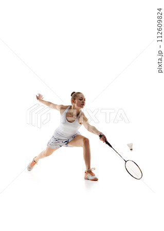 Concentrated young girl, athlete in motion with racket, playing badminton isolated over white background 112609824