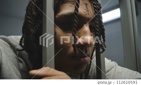 Depressed African American teenage criminal in juvenile detention center 112610591