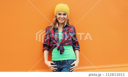 Beautiful happy smiling young blonde woman posing in casual clothes, yellow hat in the city 112611011
