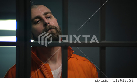 Criminal in orange uniform talks with lawyer and reads contract 112613353