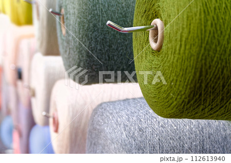 Assorted spools of multi-colored wool threads Assorted spools of multi-colored wool threads 112613940