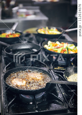 Cooking meat in a frying pan Cooking meat in a frying pan 112614076