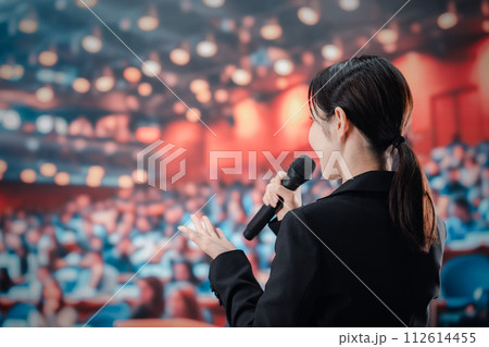 大勢の聴衆の前でスピーチをする女性 112614455