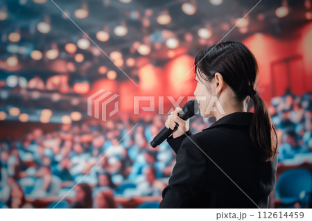 大勢の聴衆の前でスピーチをする女性 112614459