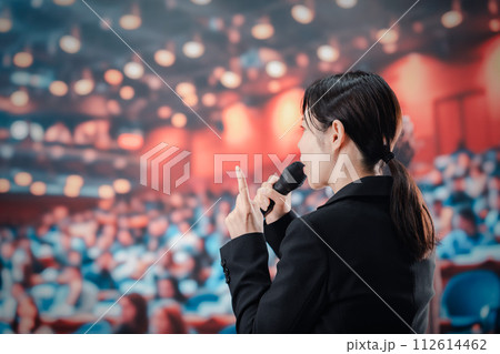 大勢の聴衆の前でスピーチをする女性 112614462