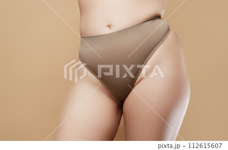 A woman's hand holds a fat cellulite and a stretch 112615607