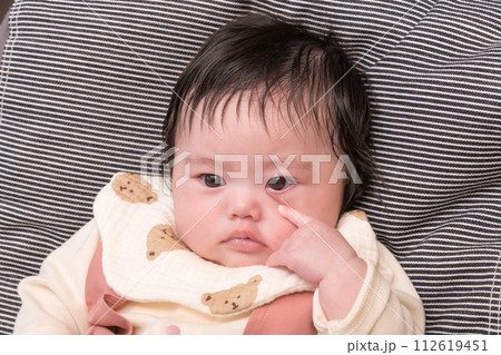 【お座りする赤ちゃんとあっかんべー】 112619451