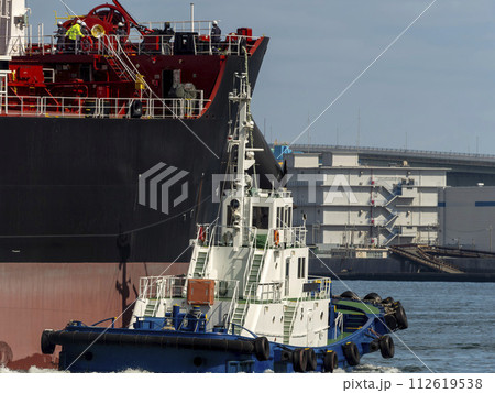 大型貨物船を誘導するタグボート 大型貨物船を誘導するタグボート 112619538