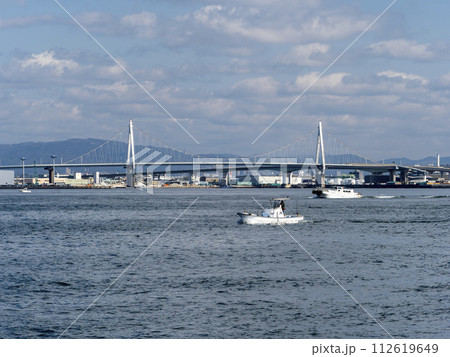 船が行き交う大阪港と此花大橋 112619649