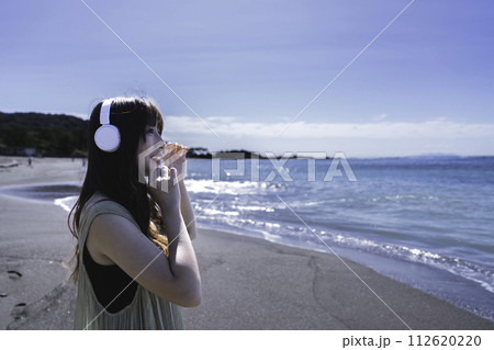 海で音楽を聴く女性 112620220