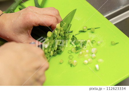 ネギを切る女性の手元 112623334