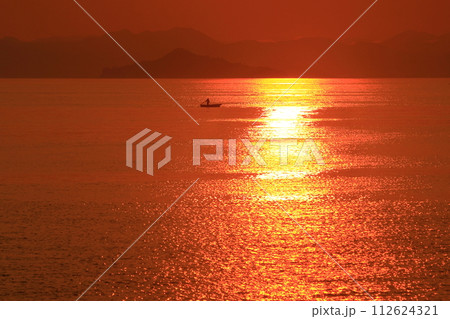 夕方の美しい瀬戸の海で漁をする一艘の船 112624321