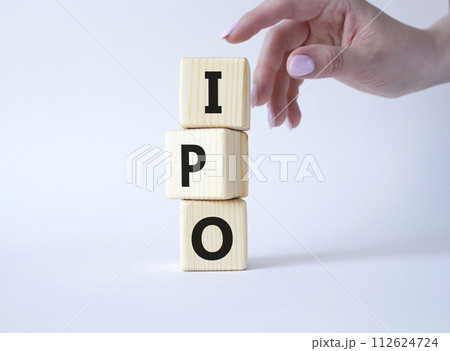 IPO- Initial Public Offering symbol. Concept word IPO on wooden cubes. Businessman hand. Beautiful white background. Business and IPO concept. Copy space. 112624724