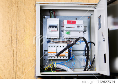 Open Electrical Panel Featuring Circuit Breakers and Wiring in Maintenance Room. Open Electrical Panel Featuring Circuit Breakers and Wiring in Maintenance Room. 112627314