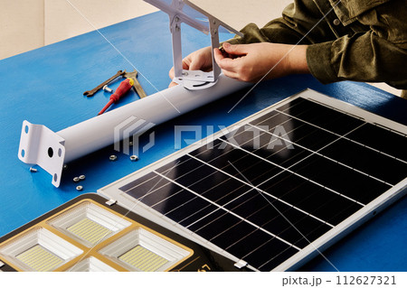 Assembling solar-powered LED street lamp, installing bracket holder for panel and lighting. Assembling solar-powered LED street lamp, installing bracket holder for panel and lighting. 112627321