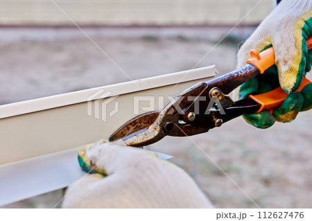 Sheet metal shears snips are used when installing window slopes on facade side. Sheet metal shears snips are used when installing window slopes on facade side. 112627476