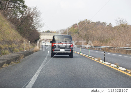 対面通行の道路を走行する車 112628197